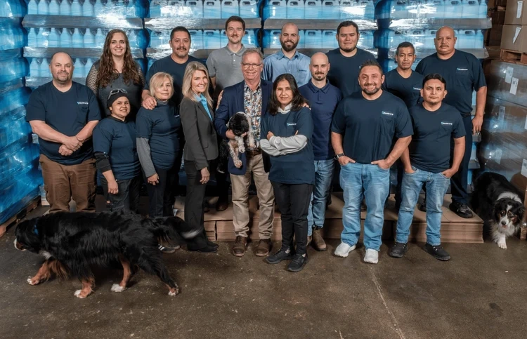 The EcoStrong team together in the warehouse with their dogs